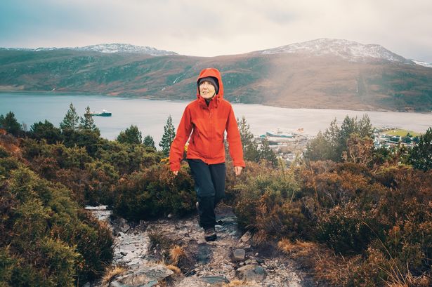 0 woman hiking above the village of ullapool by the shores of loch broom in the north west highlands of scotland